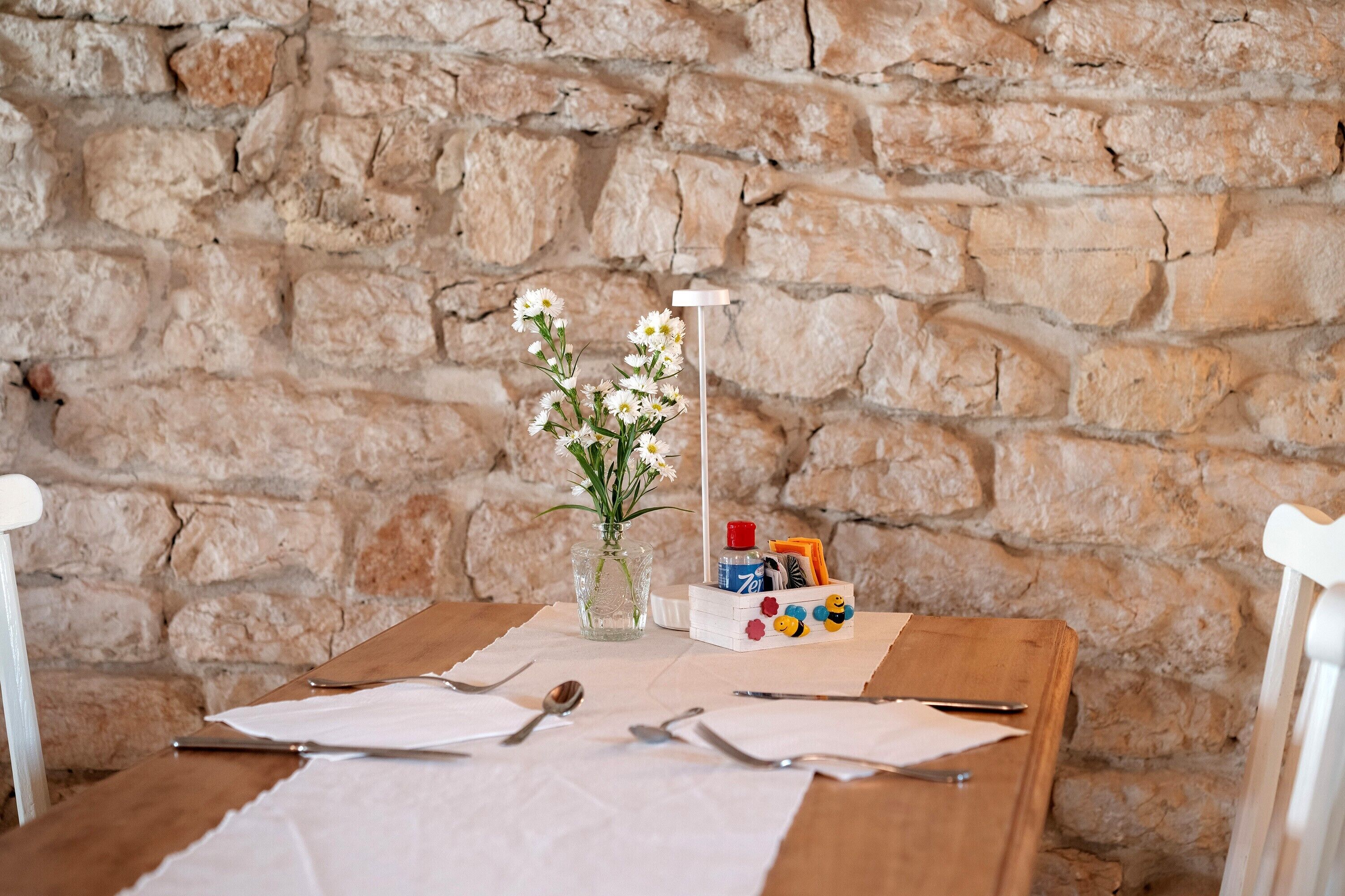 Ein Holztisch mit einer Blumenvase, einer Lampe und einer Kiste Buntstifte.