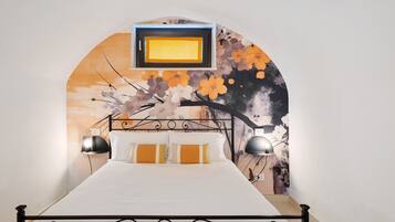 Een bed met een witte matras, een zwart metalen frame en twee bedlampjes.
