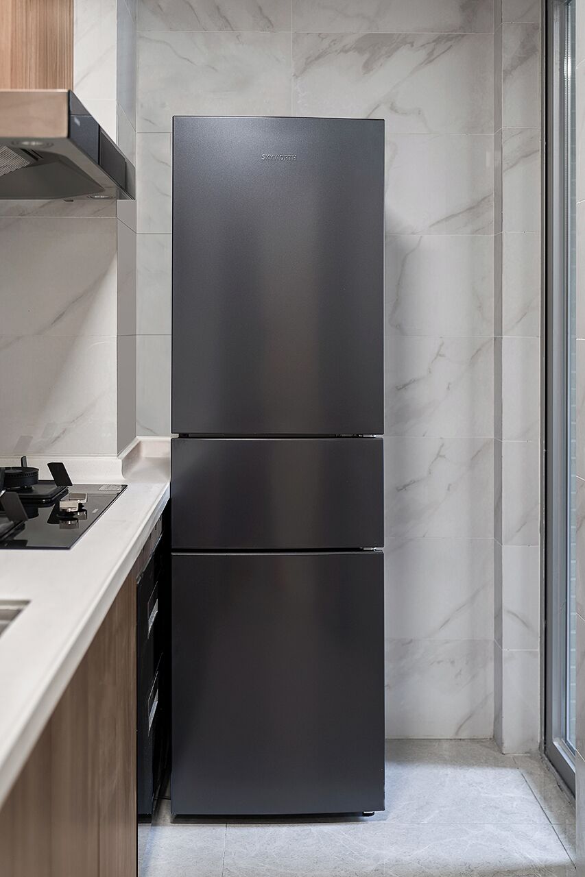 Uma cozinha moderna com uma geladeira de porta dupla em aço inoxidável, bancada de madeira e painel de fundo de mármore.