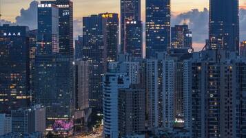 A cityscape with high-rise buildings, a curved road, and a sunset sky.