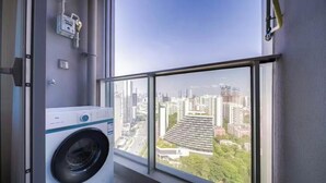 A laundry room with a large window overlooking a cityscape.