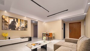 Uma sala de estar moderna com sofá, mesa de centro e área de jantar com cadeiras e mesa.