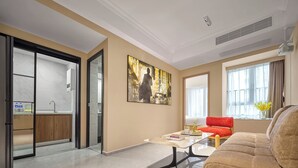 A modern living room with a sofa, a coffee table, and a painting on the wall.
