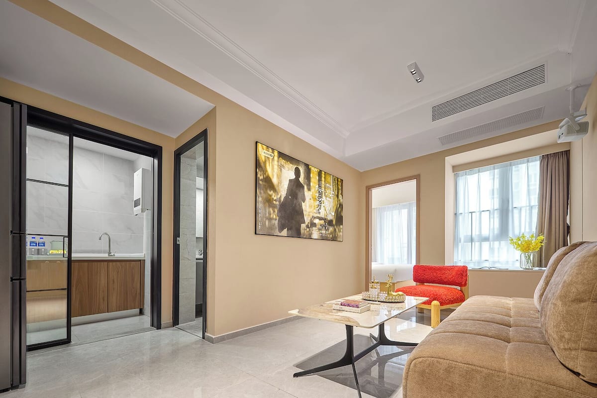 Una sala de estar moderna con un sofá, una mesa de centro y un cuadro en la pared.