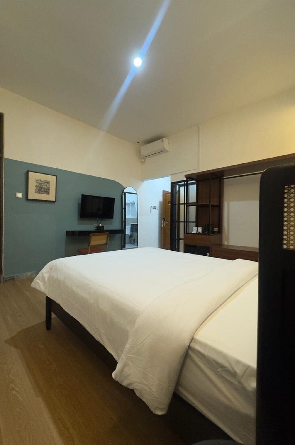 Una habitación de hotel con cama, televisión, escritorio y armario.