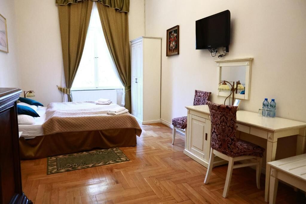 Ein Schlafzimmer mit einem Bett, einem Schreibtisch mit Stuhl, einem Fernseher und einem Kleiderschrank.