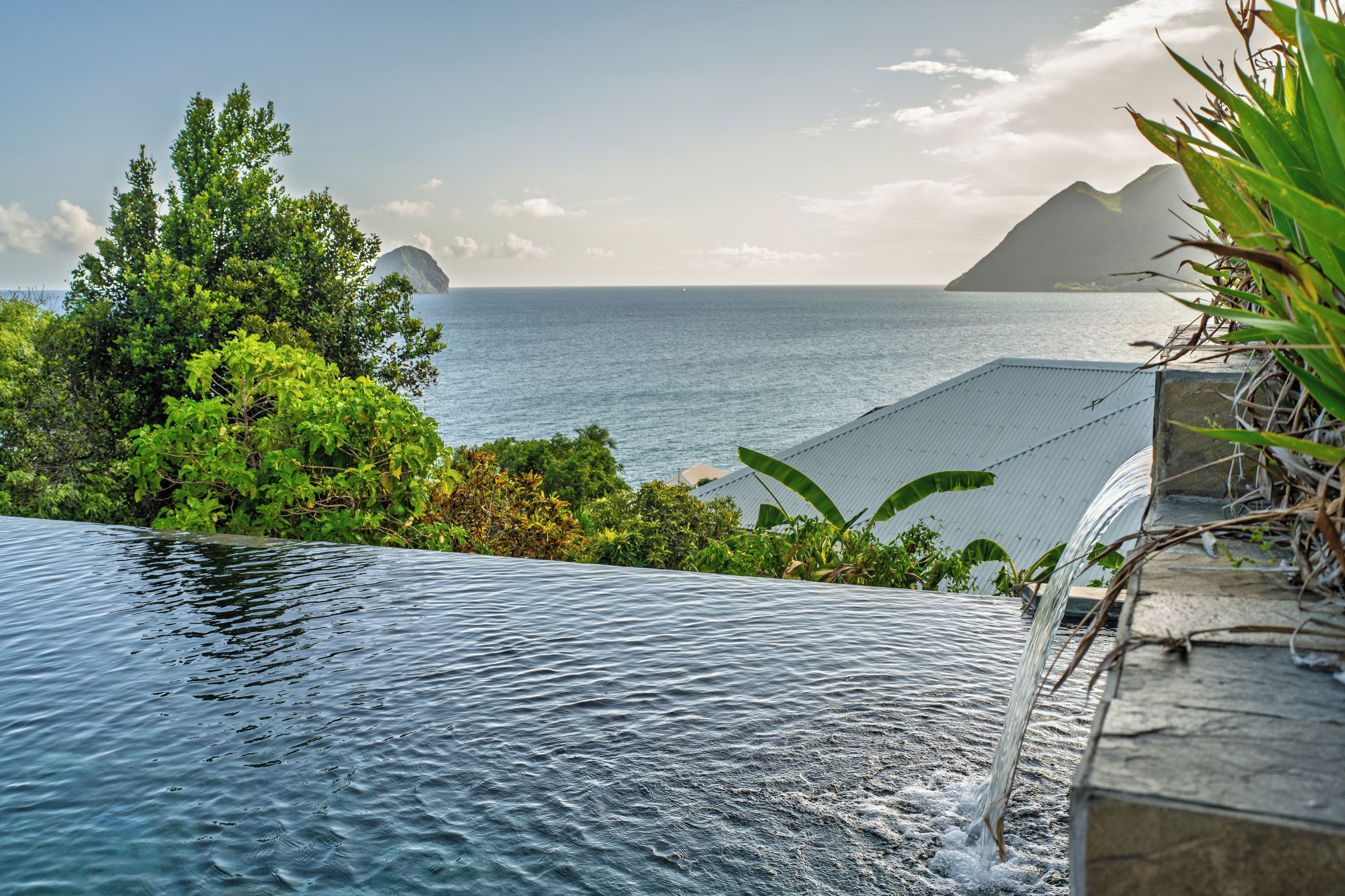 Una piscina con vista al mar y a las montañas.