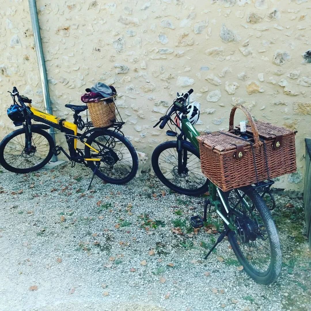 Dos bicicletas con cestas, estacionadas frente a una pared con textura.