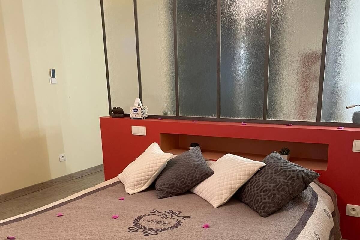 A bed with a patterned bedspread, multiple pillows, and a decorative emblem on the bed.
