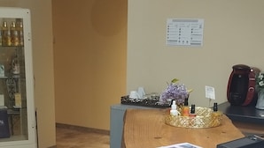 Een receptie met een klok, prikbord en een balie met papieren.