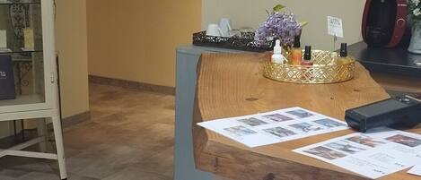A reception area with a clock, a bulletin board, and a counter with papers.