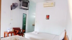 A hotel room with two beds, a desk, a chair, a TV, and an air conditioning unit. - Orchids Guesthouse (Chiang Rai)