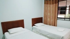 Two single beds with wooden headboards in a room with a window and curtains. - Orchids Guesthouse (Chiang Rai)