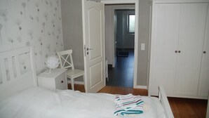 Une chambre à coucher avec un lit, une chaise, un bureau et une armoire.
