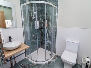 A bathroom with a glass-enclosed shower, a white sink, and a toilet. - Amber Rose (Berwick-upon-Tweed)