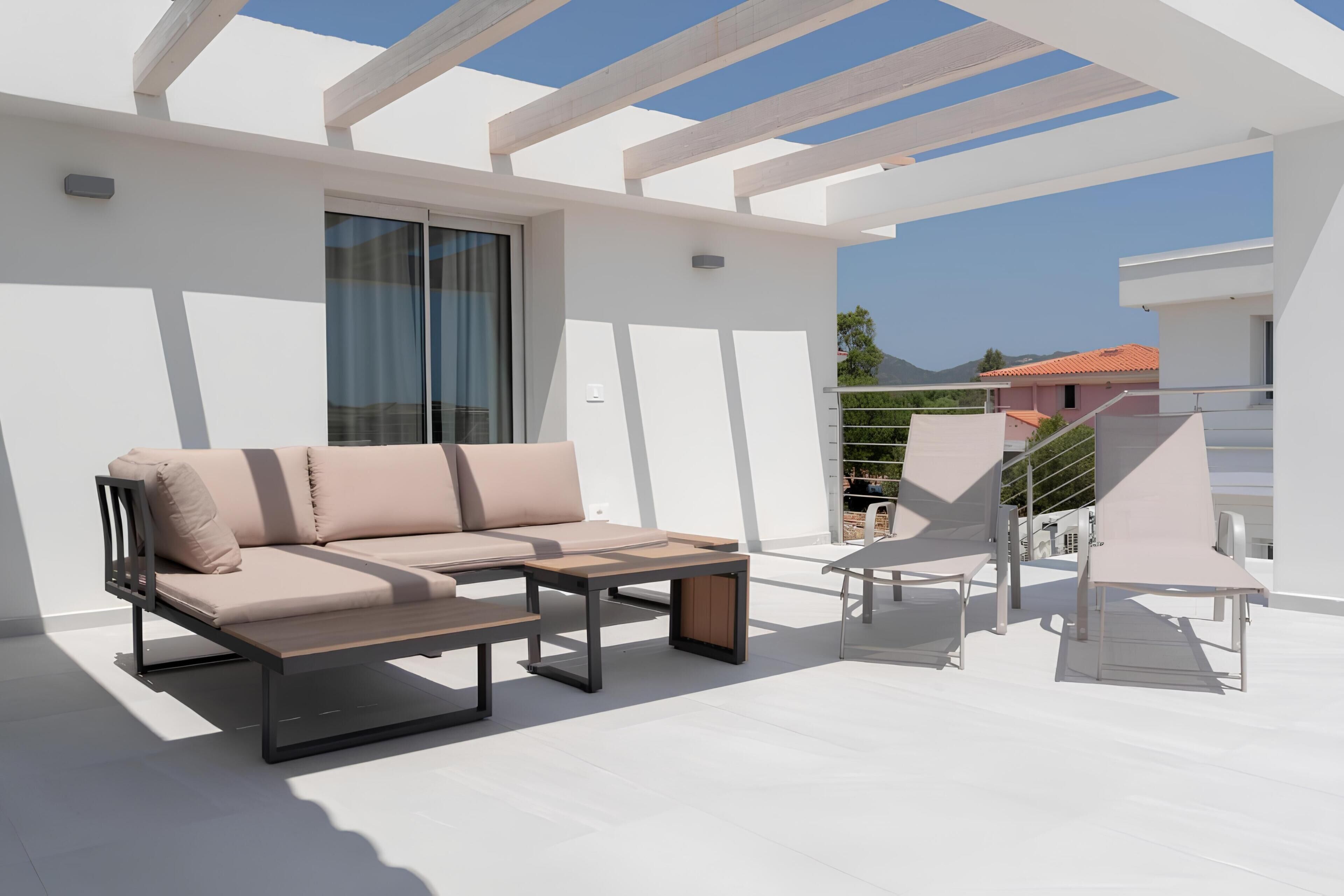 A modern outdoor patio with a sofa, a table, and chairs.