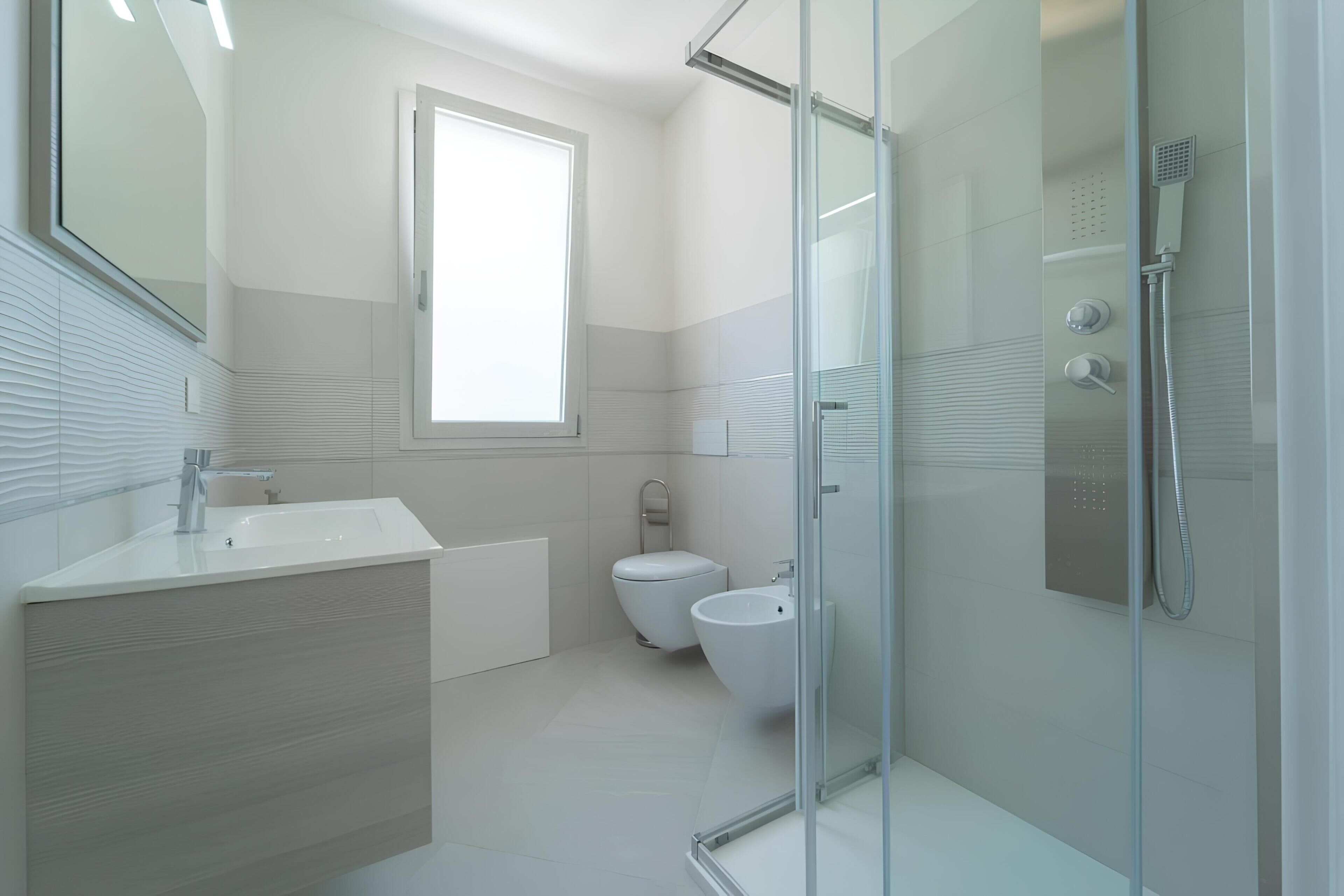 A modern bathroom with a glass shower enclosure, a toilet, and a sink.