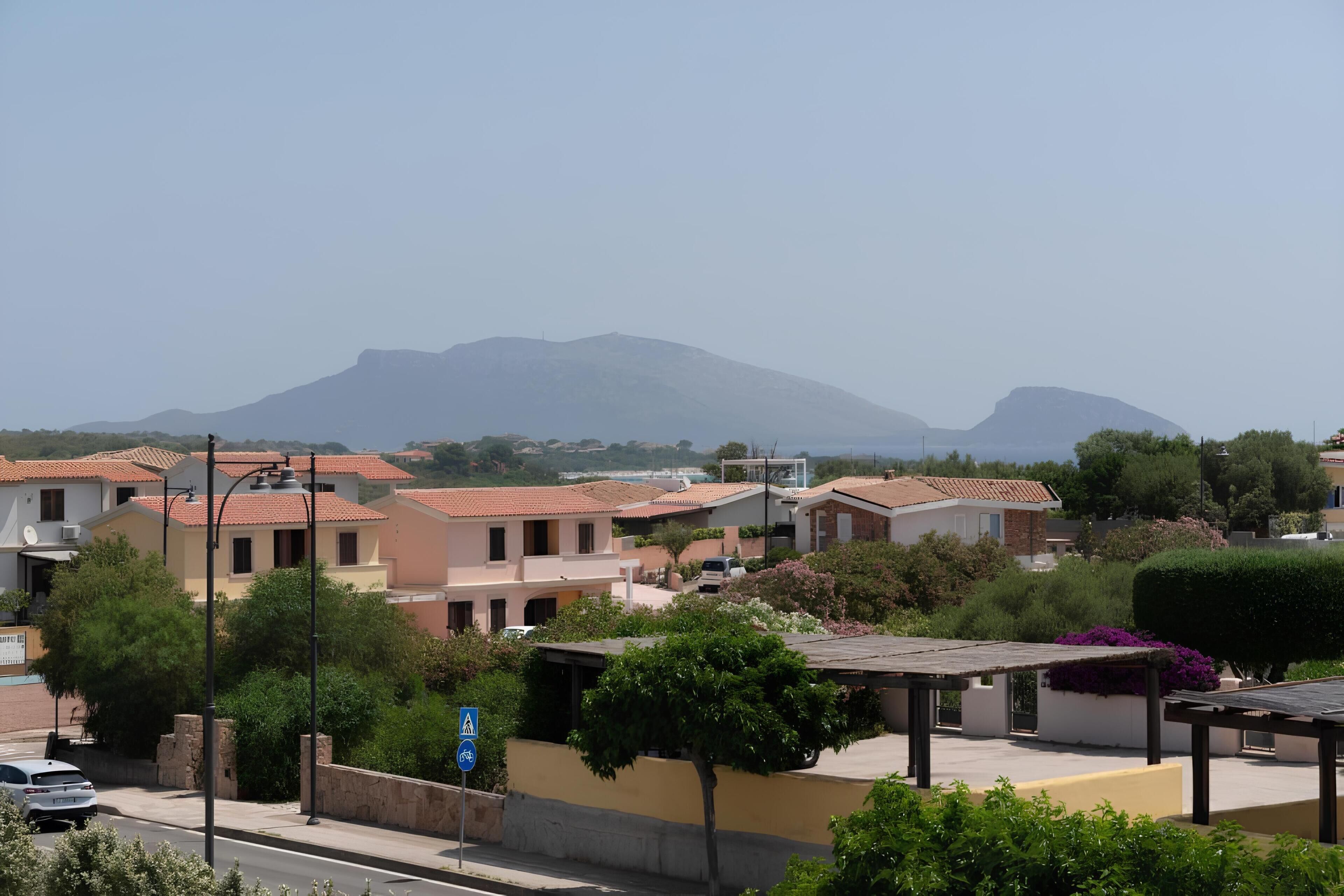 Zona residencial con casas, una calle y una montaña al fondo.