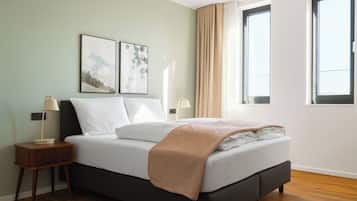Ein Schlafzimmer mit einem Bett, zwei Nachttischen, einem Fenster und Bildern an der Wand.