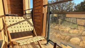 A wooden deck with a round table, two bottles of beer, playing cards, and a book titled 'Les Assassins de la Lune'. - KerTerra Corsica - Apartment 3 Bedrooms- 6 Pers - Heated pool & private beach (Pianottoli-Caldarello)