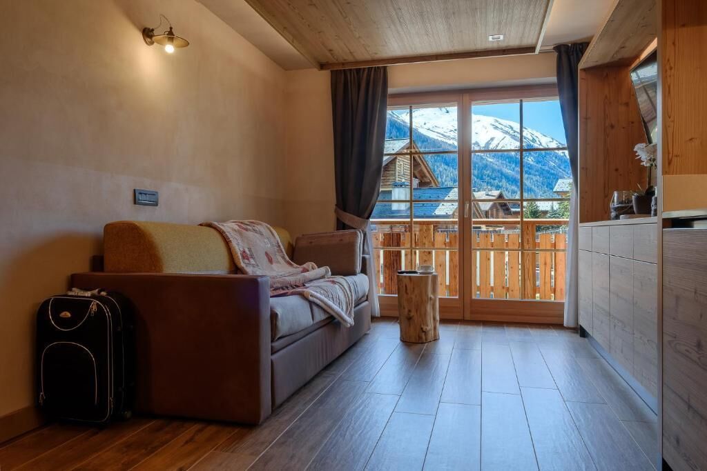 Una habitación acogedora con un sofá, una mesita y una ventana con vistas a montañas.