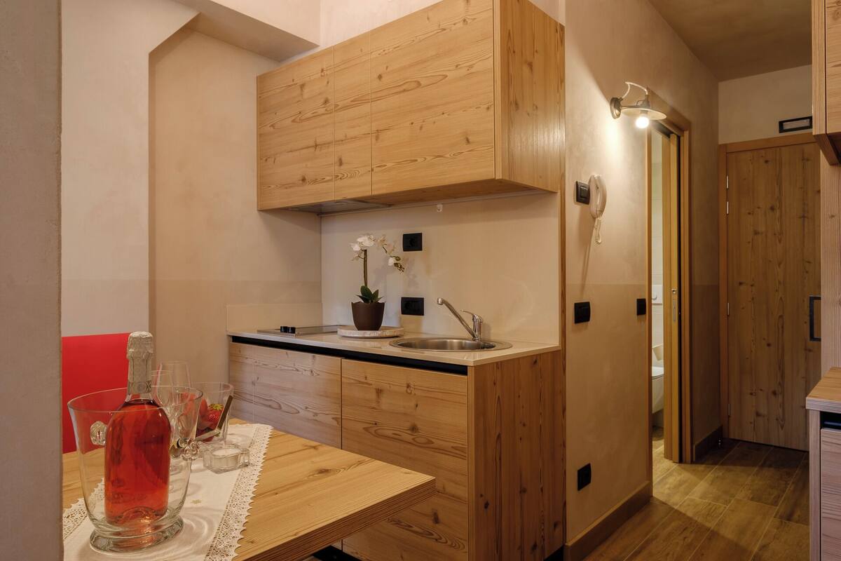 A compact kitchen with wooden cabinetry, a sink, and a small countertop.