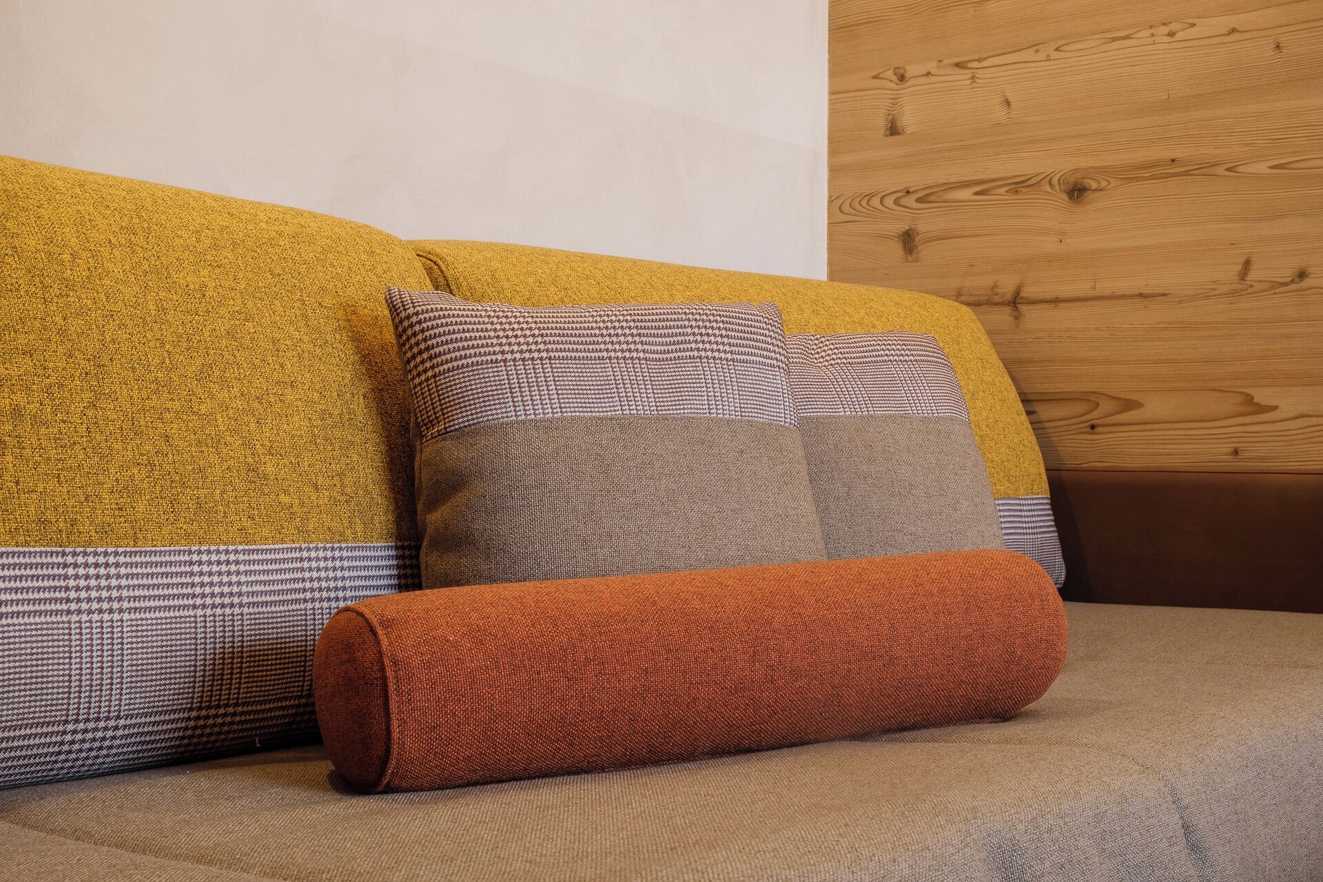 A sofa with multiple cushions in various colors and patterns.