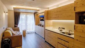 Una cocina moderna con armarios de madera, horno empotrado y un amplio ventanal con cortinas.