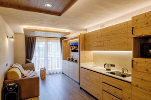 Una cocina moderna con armarios de madera, horno empotrado y un amplio ventanal con cortinas.