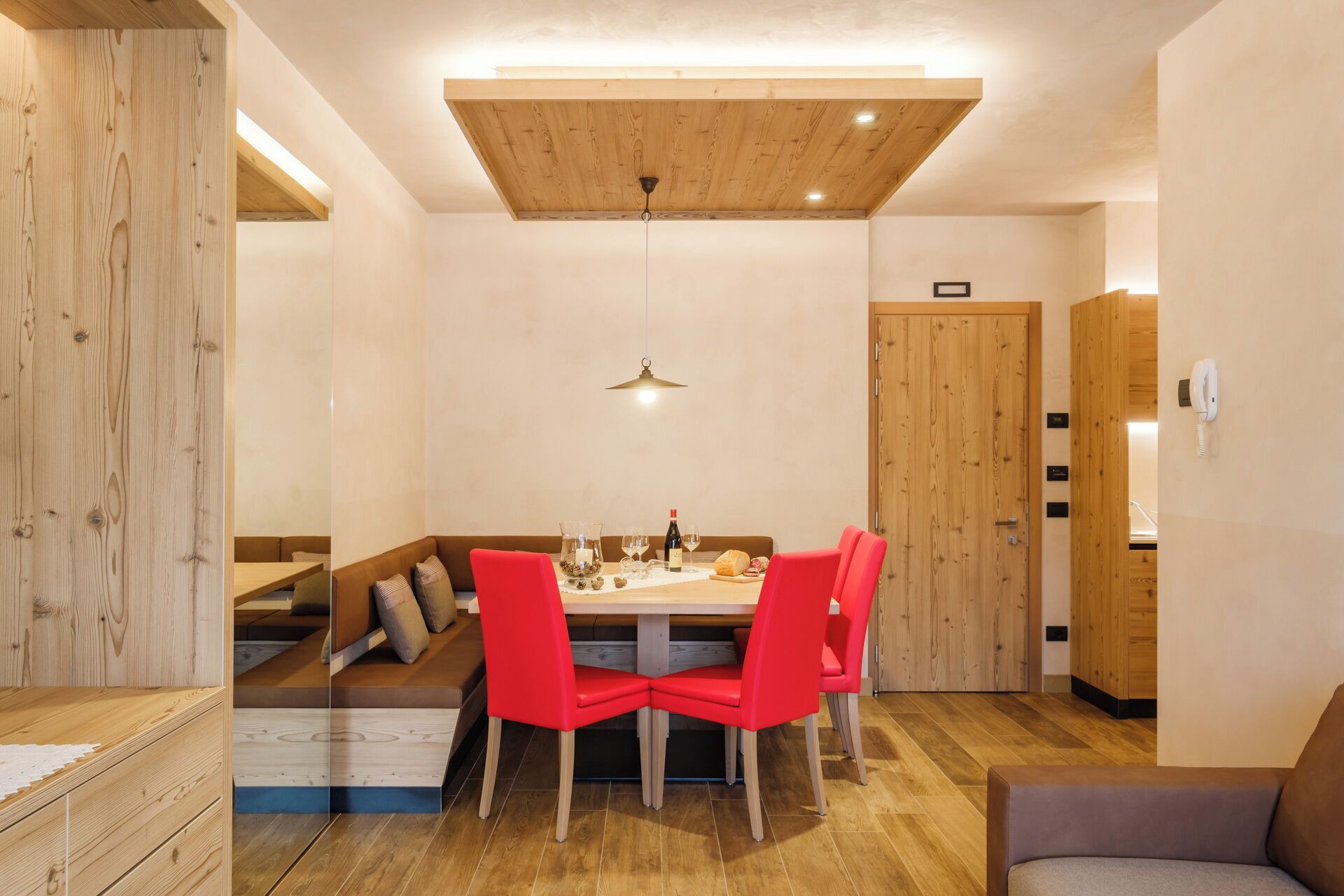 Un comedor con techo de madera, una mesa con sillas y un sofá.