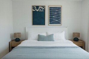 A bed with white bedding, a single pillow, and two nightstands with lamps. - OB Townhome, 2 blocks to beach with Private Garage (San Diego)