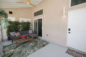 A covered patio area with a sofa, a coffee table, and a potted plant. - Heart of OB, Walk to Beach, Townhome with Garage and Patio (San Diego)