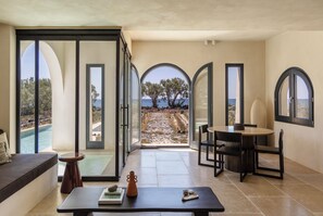 A modern interior with a view of the sea, a dining area, and a seating space. - Exomitis1 Cellar & Sea Escape (8CMR+3XX Exomitis, Greece)