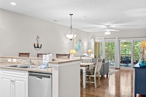 A kitchen with a dishwasher, a sink, and a dining area with chairs and a table. - 3 bedroom in gated community. Walk to the beach. (North Myrtle Beach)