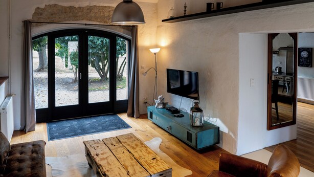 Una sala de estar con una mesa de centro de madera, un sofá de cuero y un televisor.