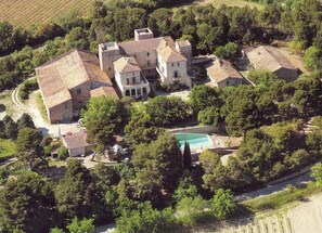 An aerial view of a large estate with multiple buildings, a swimming pool, and surrounding greenery. - demi-château de Paulignan for 15 people (TRAUSSE)