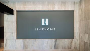 Eine Wand mit einem großen Schild, das das 'LIMEHOME'-Logo und den Schriftzug zeigt.