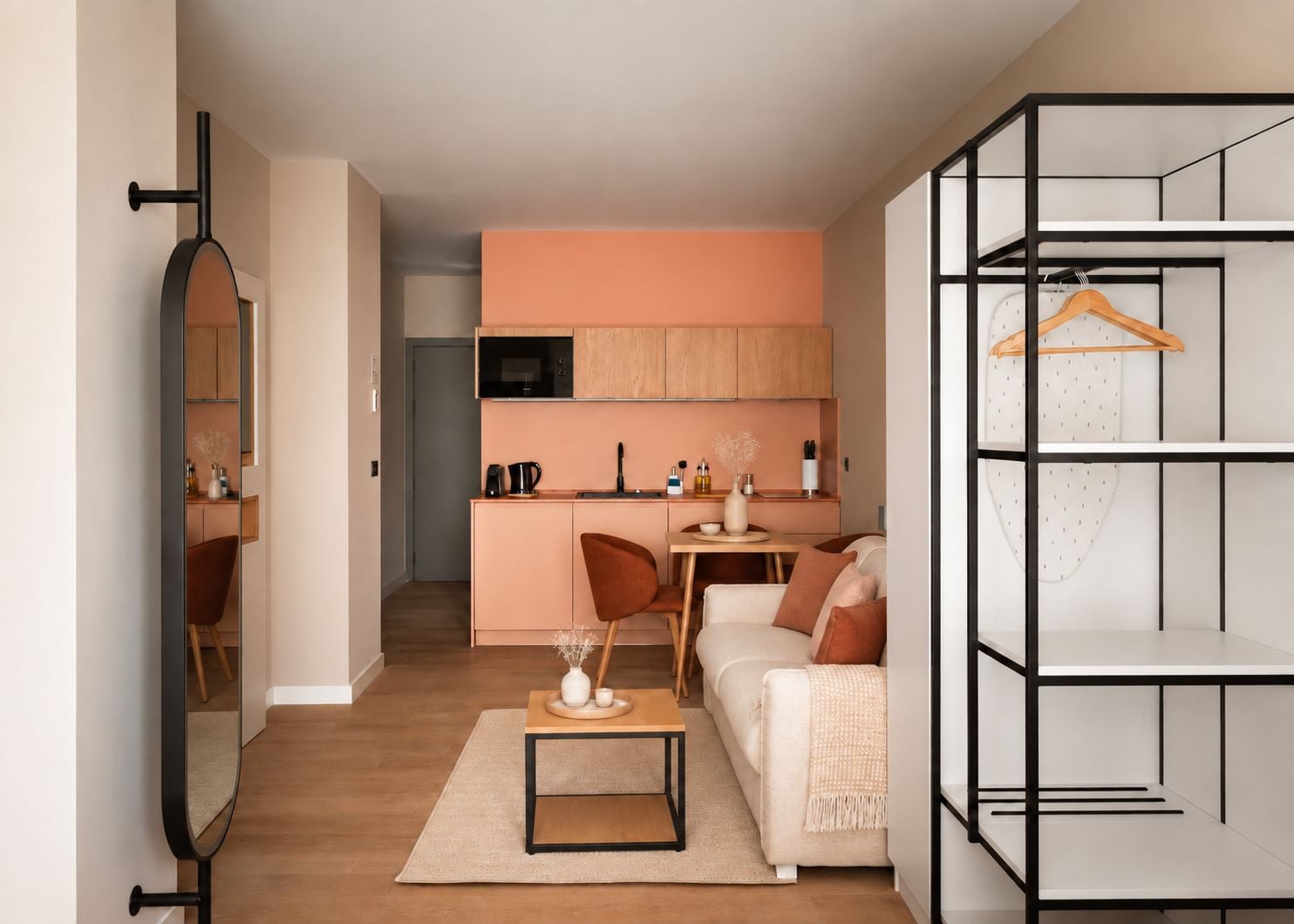 Un apartamento moderno con kitchenette, zona de comedor y sala de estar con sofá y mesa de centro.