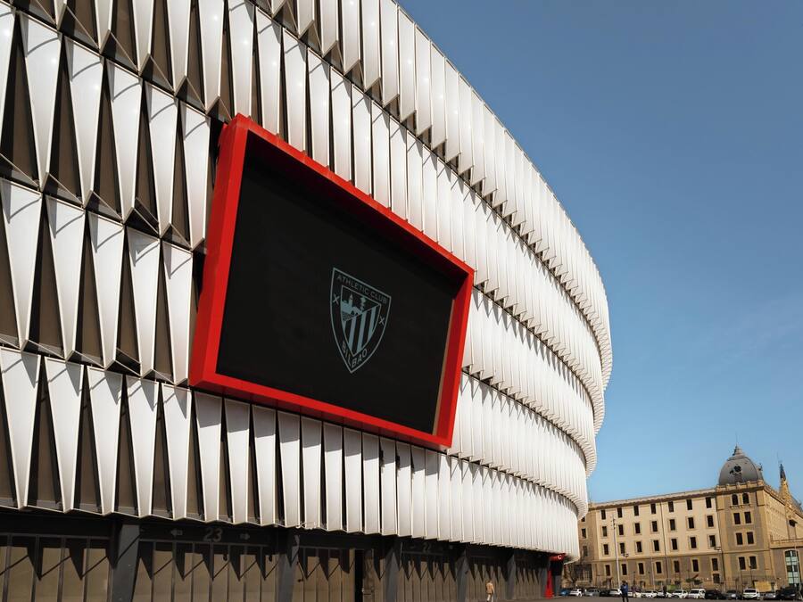 Un edificio con una fachada geométrica distintiva y un escudo prominente en la parte frontal.