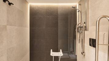 A modern bathroom with a shower, a white sink, and a glass-enclosed shower area.
