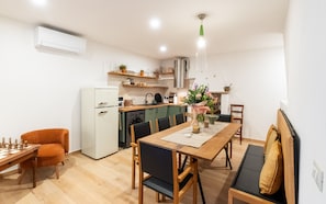 A compact kitchen with a dining area, including a wooden table, chairs, and a chessboard. - Homestay 'Residenza Tre Cuori' with Lake View, Wi-Fi and Air Conditioning (Torri del Benaco)