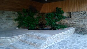 A stone staircase leading to a seating area with a stone wall and wooden paneling. - Vacation Rental in Beauvoir with Wi-Fi, Family-Friendly, Pets Welcome (Beauvoir)