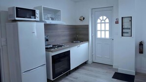 Eine kleine Küche mit Mikrowelle, Backofen und Spüle.