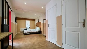 Ein Hotelzimmer mit Bett, Schreibtisch, Heizkörper und Tür.