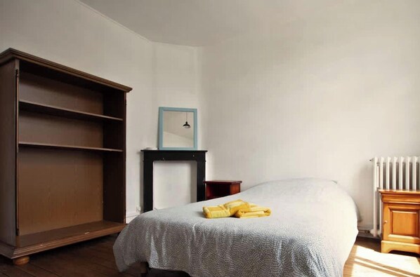 A bedroom with a bed, a wardrobe, a small table with a mirror, and a radiator. - La Brocante 4 ch Centre Lens Cour Parking 8p (Lens)