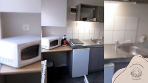 Uma cozinha compacta equipada com micro-ondas, cafeteira e máquina de lavar louça pequena.