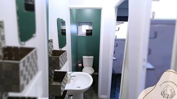 Un baño con inodoro, lavabo y espejo.