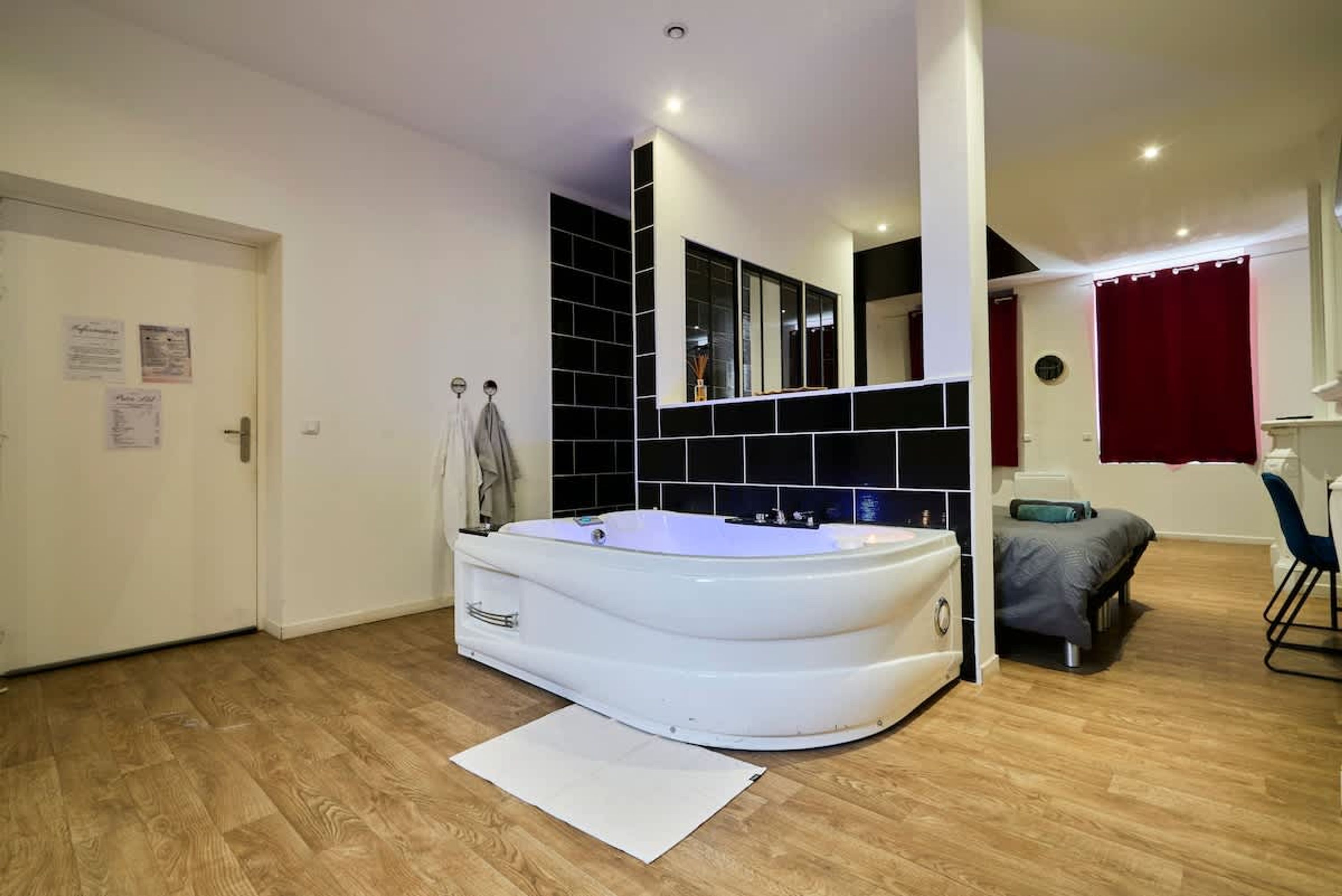 A modern bathroom with a freestanding bathtub, a mirror, and a shower area.