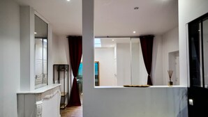 A modern interior with a white wall, a mirror, a window with curtains, and a door. - Baignoire Blaneo Sauna 10 Minutes de la Gare (Tourcoing)