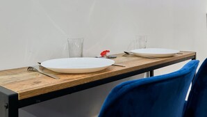 A dining table with two white plates, a fork, a knife, and two clear glasses. - Baignoire Blaneo Sauna 10 Minutes de la Gare (Tourcoing)